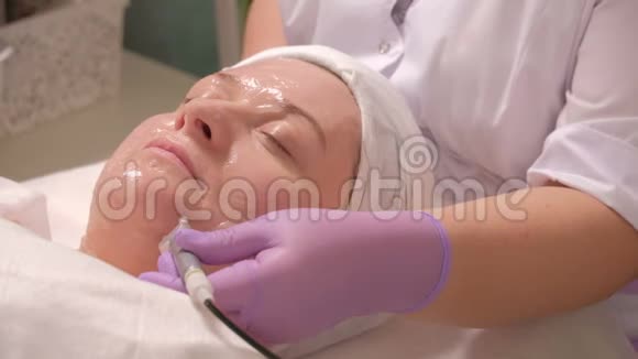 一位中年妇女在美容院做手术提升肤色一位专业的美容师抚平皱纹视频的预览图