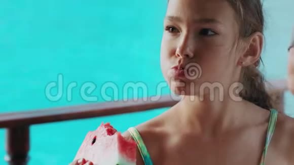 少女在碧海背景下吃着成熟的西瓜视频的预览图