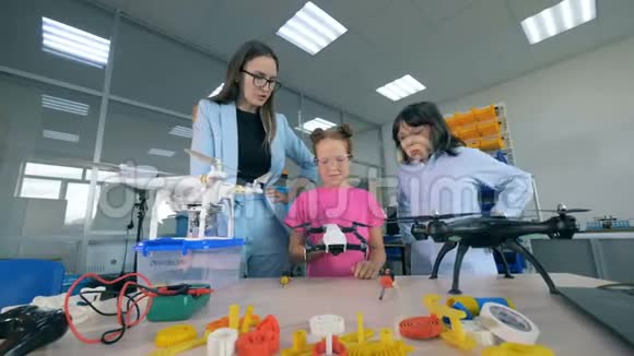 女研究员和两个学童正在探索无人驾驶飞机教育理念的创新视频的预览图