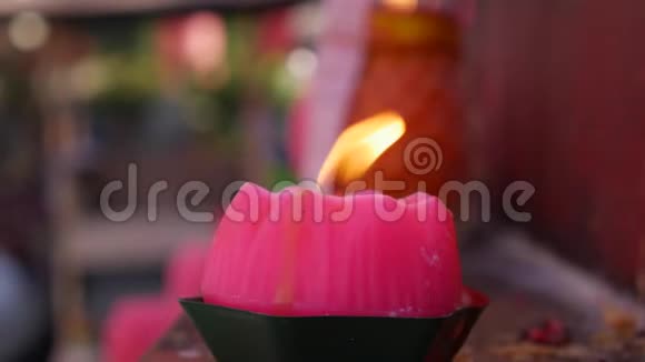 在庆祝中国新年的时候在道观点燃粉红蜡烛的火焰4k视频的预览图