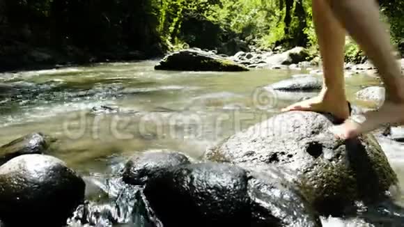 穿着泳衣的女人坐在石头上在冰冷的河流里泼水视频的预览图