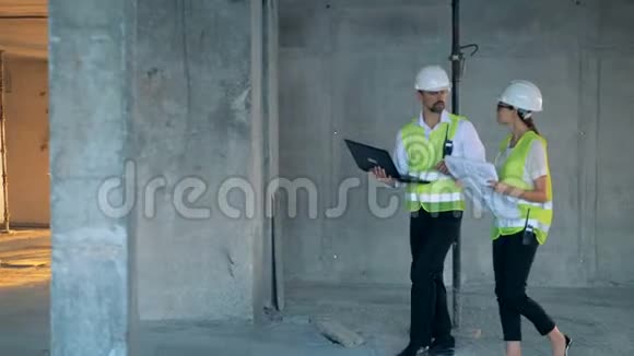 建筑师在一座未完工的大建筑里行走时讨论他们的工作视频的预览图