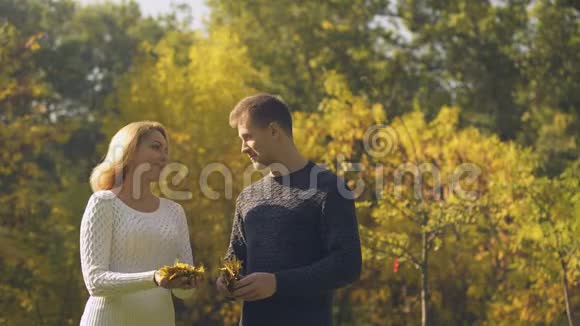一对快乐的夫妻把秋叶扔起来一起玩视频的预览图