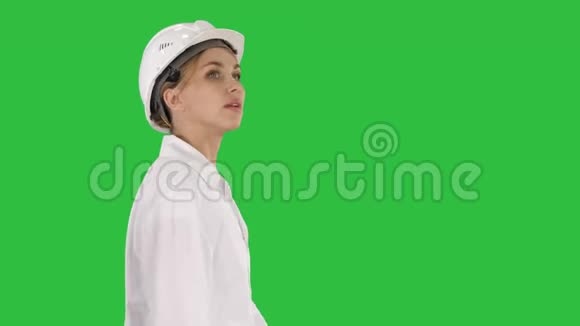 戴着安全帽的年轻女子在绿色屏幕上走来走去Chroma键视频的预览图