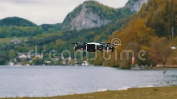 在湖和山的背景下悬挂在空中的旋转螺旋桨视频的预览图