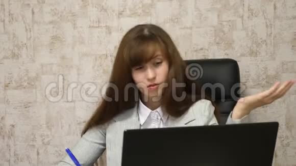 电脑上的在线商务对话女孩坐在电脑办公室的椅子上在笔记本上做笔记年轻青年视频的预览图
