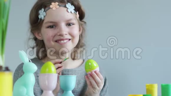 少女为复活节准备装饰品用刷子抹复活节彩蛋笑得不好意思视频的预览图