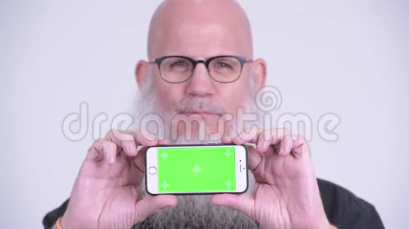 一脸快乐成熟的秃头男人展示电话视频的预览图