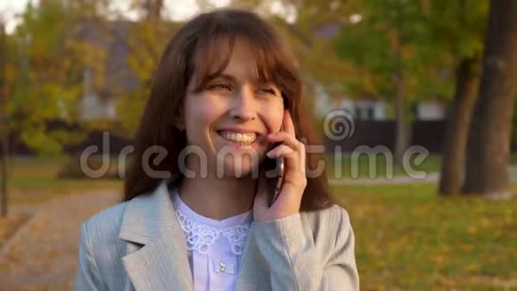 幸福的女人在手机上说话在街上微笑视频的预览图