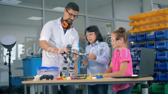 工程游戏室有两个十几岁的孩子还有一个男工认识一个玩具机器人视频的预览图