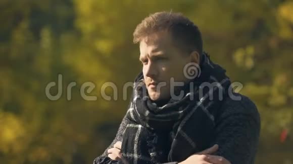 患病男性戴围巾在秋季公园咳嗽和打喷嚏感冒感染视频的预览图