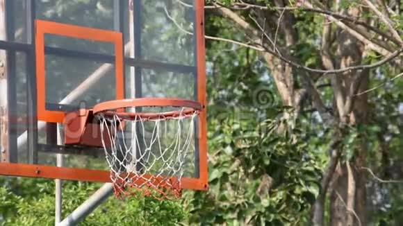 篮球篮筐和网摇球落下背景树在公园里视频的预览图