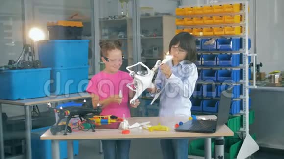 两个十几岁的孩子正在组装一架四翼飞机无人机并在玩它视频的预览图