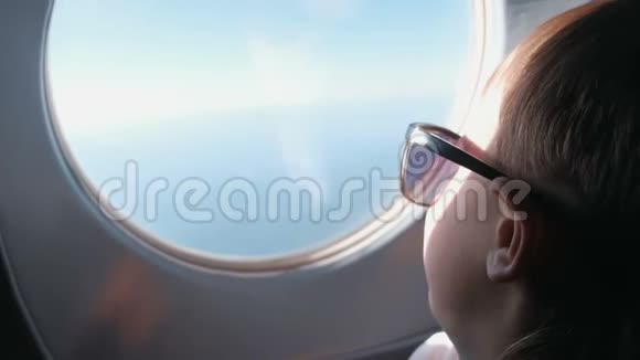 面目全非的男孩戴着太阳镜望着窗外的飞机视频的预览图