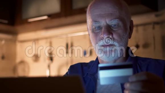 家里用笔记本电脑的老人退休人员晚上用电脑上网购物视频的预览图