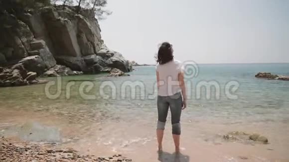 托马尔西班牙吉罗纳年轻的白种人女孩举起手来享受生活站在夏季的海洋海滩上视频的预览图