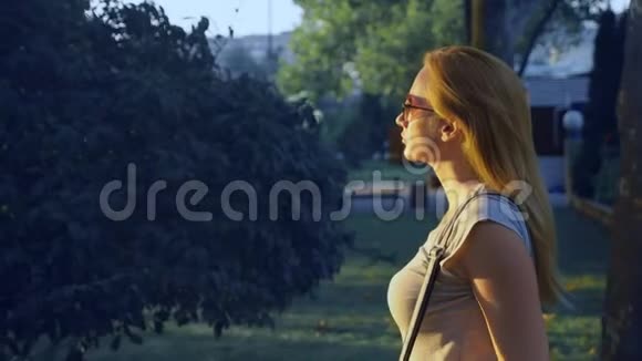 一个年轻的蓝眼睛女人站在商场的公园里的肖像4慢镜头拍摄视频的预览图