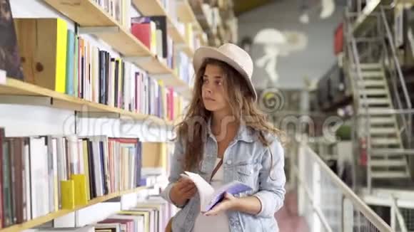 在书架上选书的女孩视频的预览图