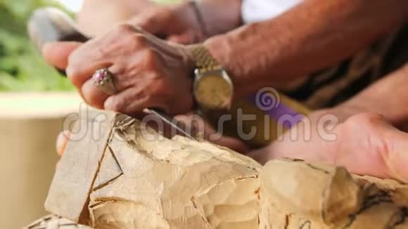 木工用锋利的工具在木制工件上雕刻传统巴厘岛小雕像制作工艺印度尼西亚巴厘视频的预览图