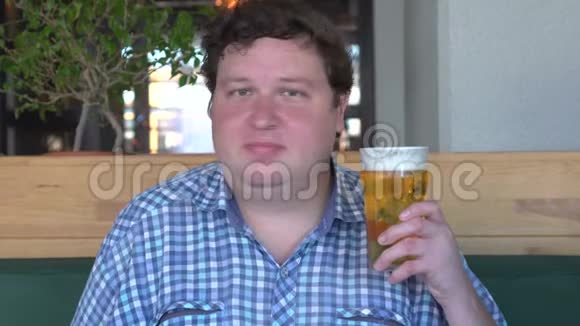 英俊的胖子拿着一杯啤酒用头说不视频的预览图