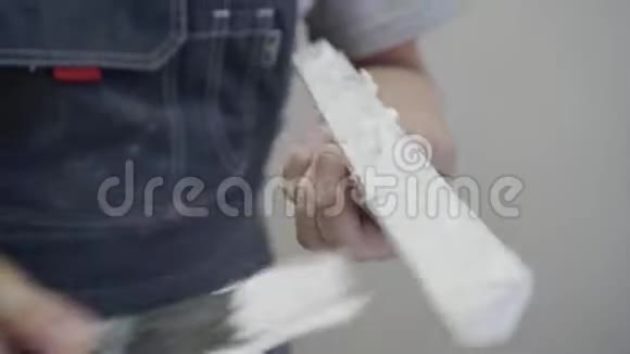 工人在白色灰泥成型的一个细节上涂上胶水准备把它固定在墙上特写过程视频的预览图