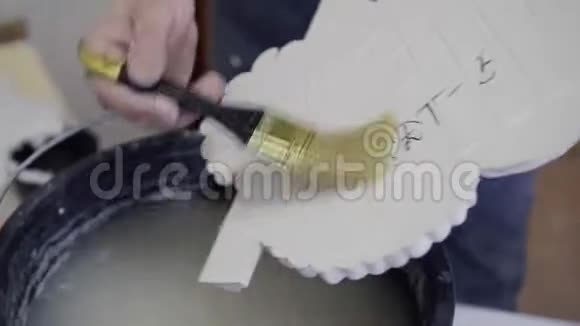 设计师在一桶水中润湿刷子用刷子滋润灰泥的细节完成apa的过程视频的预览图