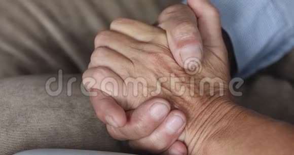 年长的祖父母夫妇手牵手近距离观看视频的预览图