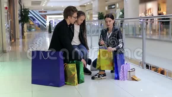 快乐的一家人拿着包裹在购物中心走来走去视频的预览图
