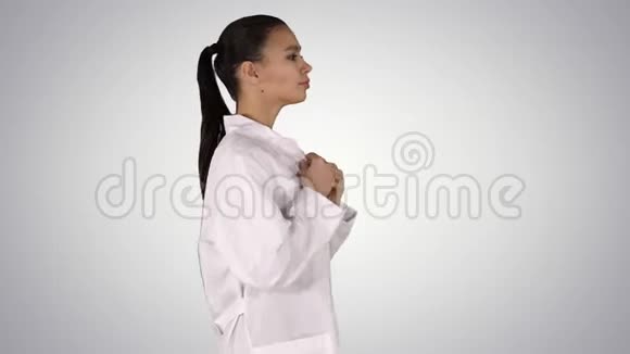 年轻的女药剂师穿着白色长袍穿着制服走在渐变的背景上视频的预览图