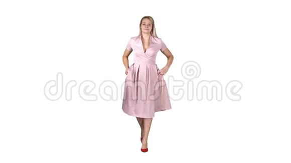 一位身穿粉红色连衣裙双手插在口袋里的女士正朝着白底相机走去视频的预览图