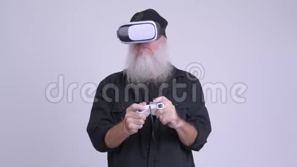在使用虚拟现实耳机的同时玩游戏的成熟有胡子的时髦男人视频的预览图