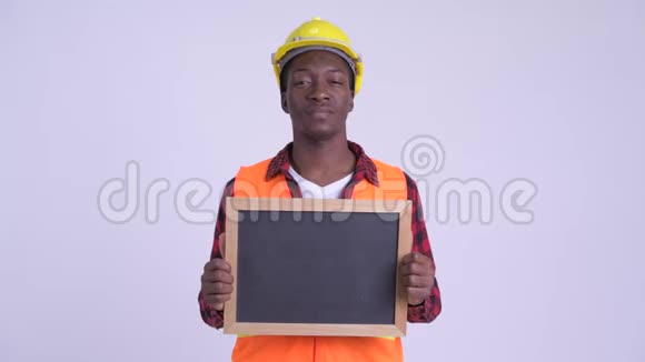 年轻快乐的非洲建筑工人举着黑板视频的预览图