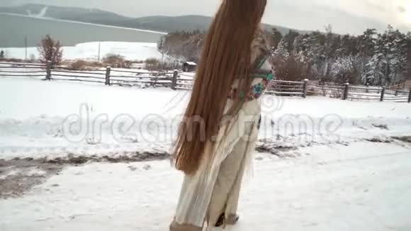在白雪覆盖的道路上行走的少数民族女孩文化视频的预览图