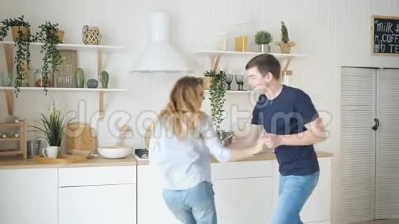 现代厨房里一个金发姑娘在桌炉旁跳舞视频的预览图
