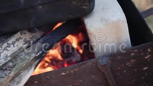 在烤架上的火堆上堆上柴火和煤做饭视频的预览图