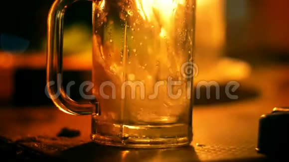 特写镜头有人在休息室的酒吧里用温暖的烛光把一杯汽水倒进桌子上的玻璃杯里视频的预览图