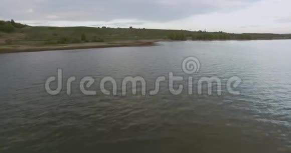 摄像机低空飞过一个大湖的水面并逐渐接近海岸视频的预览图