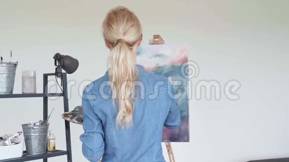 女青年画家家中绘画创作后景视频的预览图