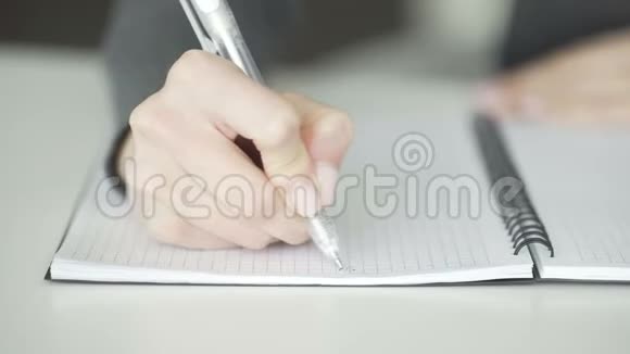 女人用钢笔在笔记本上写字视频的预览图
