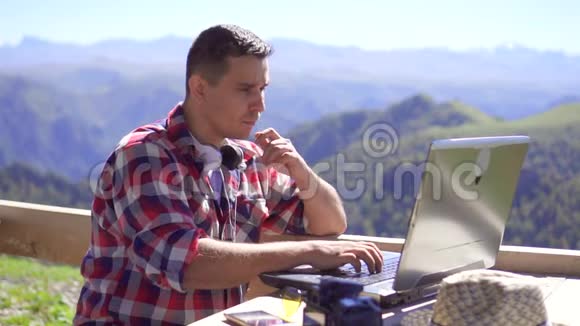 一个自由职业者在山区背景下的笔记本电脑上打字的肖像慢莫视频的预览图