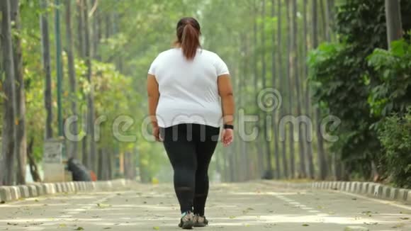 在公园散步的超重妇女的后景视频的预览图