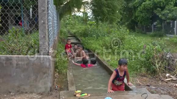 越南村庄稻田运河中的儿童洗澡视频的预览图