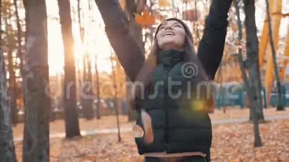 秋天公园里快乐的女人落叶秋天视频的预览图