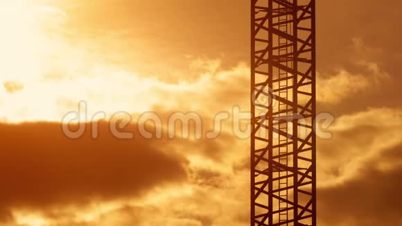 施工现场塔吊梯子在日落光线下暖橙色的天空中视频的预览图