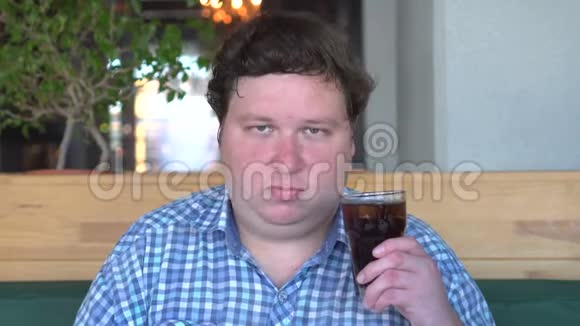 胖子在咖啡馆里喝着一杯可乐摇头说是的视频的预览图