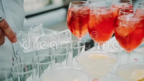 专业的酒保在酒吧准备鸡尾酒酒吧服务员准备鸡尾酒在玻璃杯中加入冰块视频的预览图
