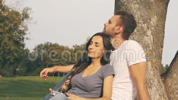 幸福的夫妇坐在树旁视频的预览图