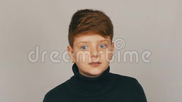 一个滑稽的红头发和蓝眼睛的少年男孩的肖像用手势和面部表情表示谴责视频的预览图