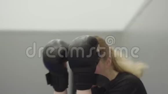 一位年轻的金发女孩戴着拳击手套在镜头前翻脸视频的预览图