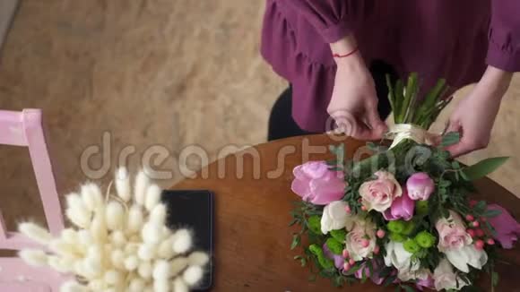 将女性双手绑在花束的蝴蝶结上视频的预览图